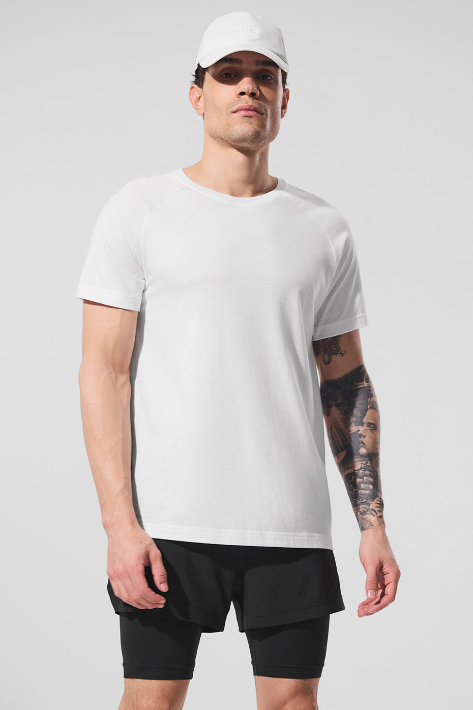 Front view of Arctic White raglan tee shirt laid flat on rustic wood background.