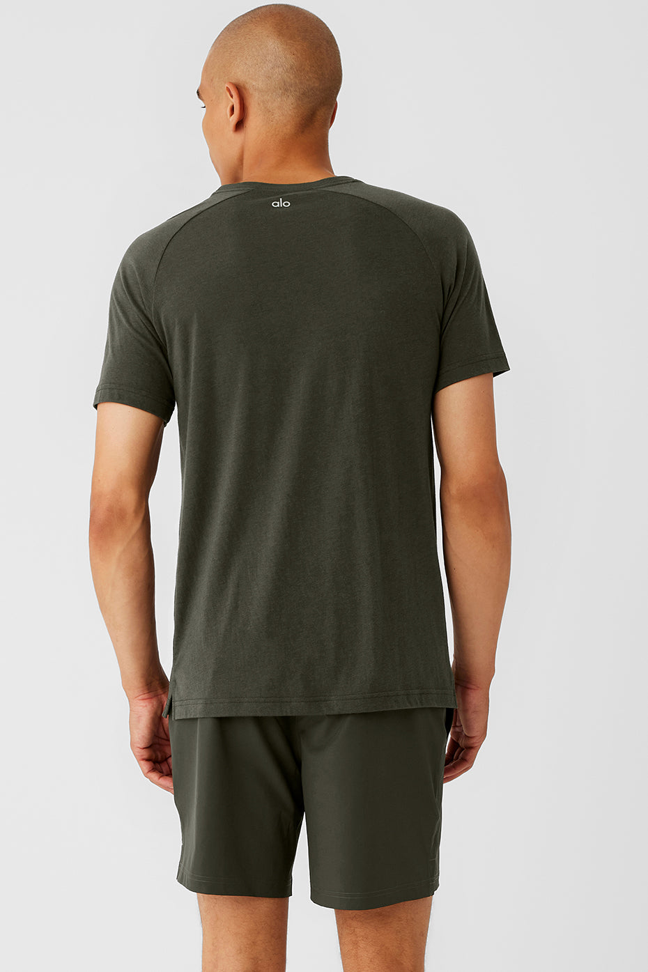 Model wearing the Triumph Raglan Tee in Stealth Green during a casual outing.