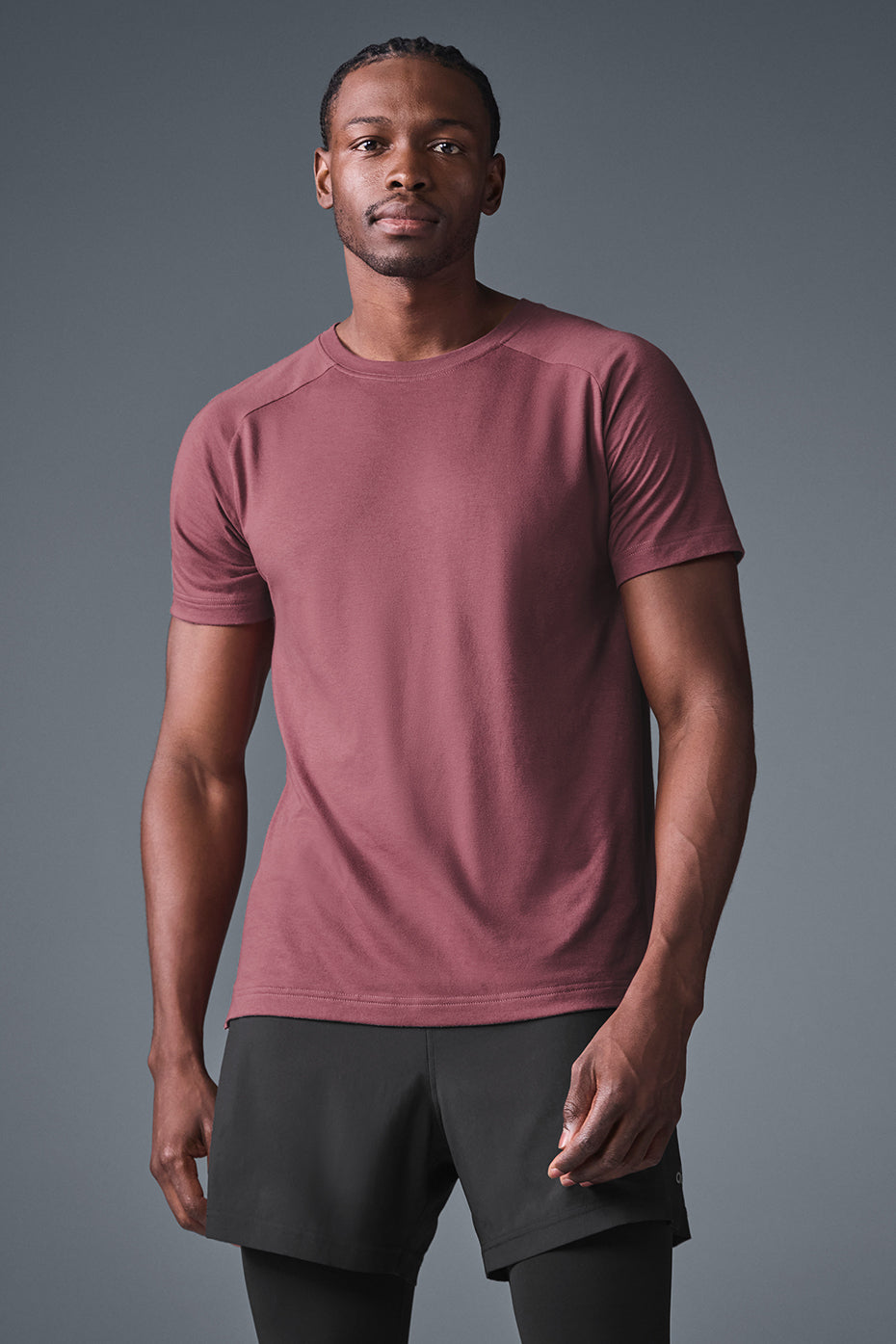 Model wearing slim fit burgundy t-shirt with raglan sleeves in outdoor café setting
