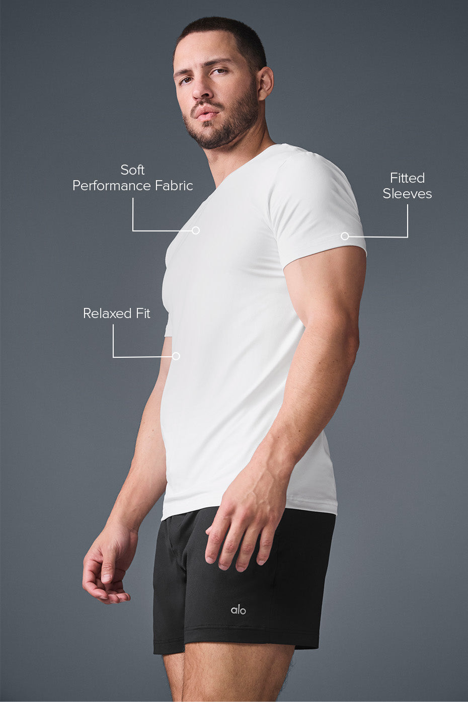 Model wearing short sleeve gym shirts men in white while walking through urban park.