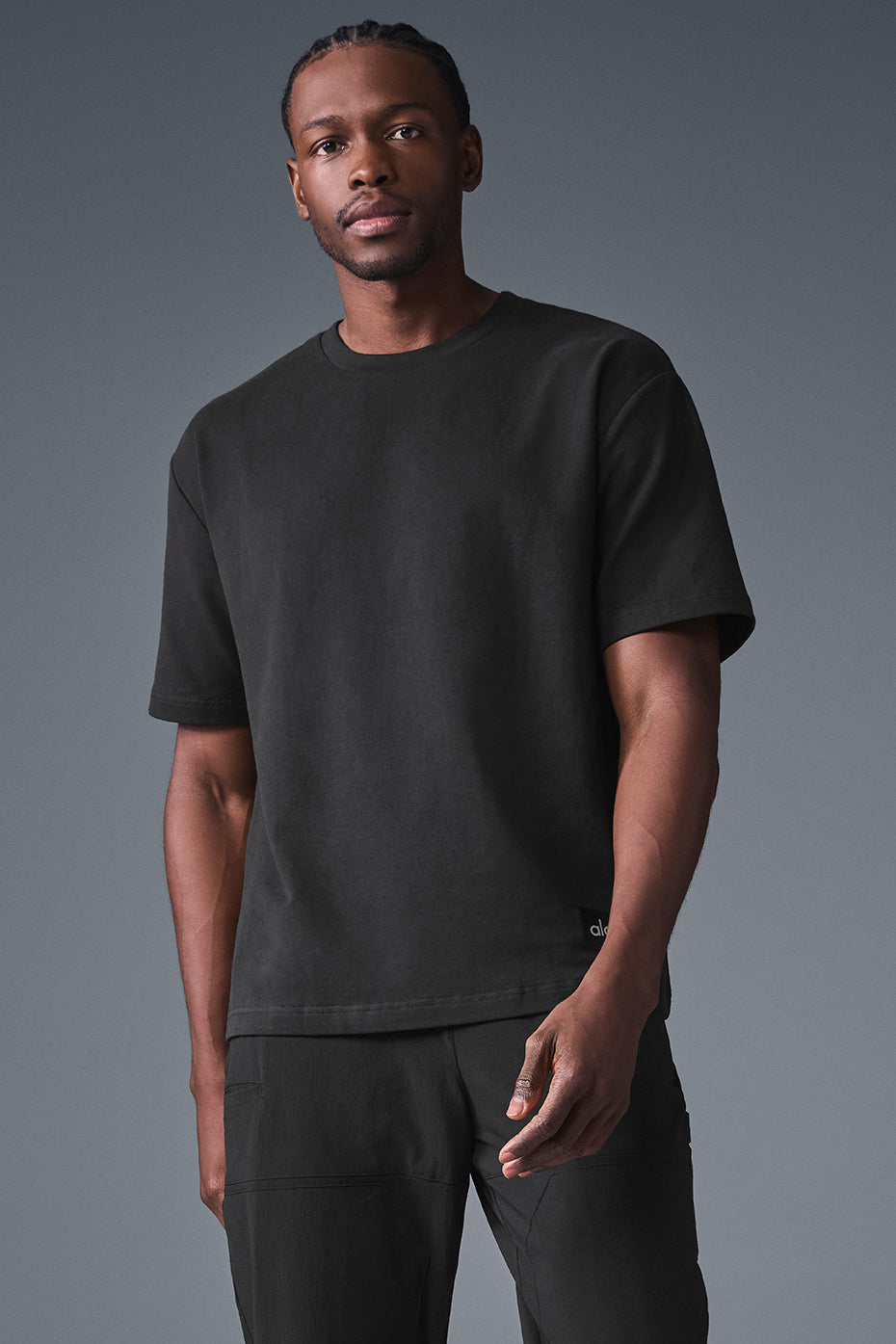 Close-up of the thick, textured fabric of the black t shirt, showing the slightly oversized fit