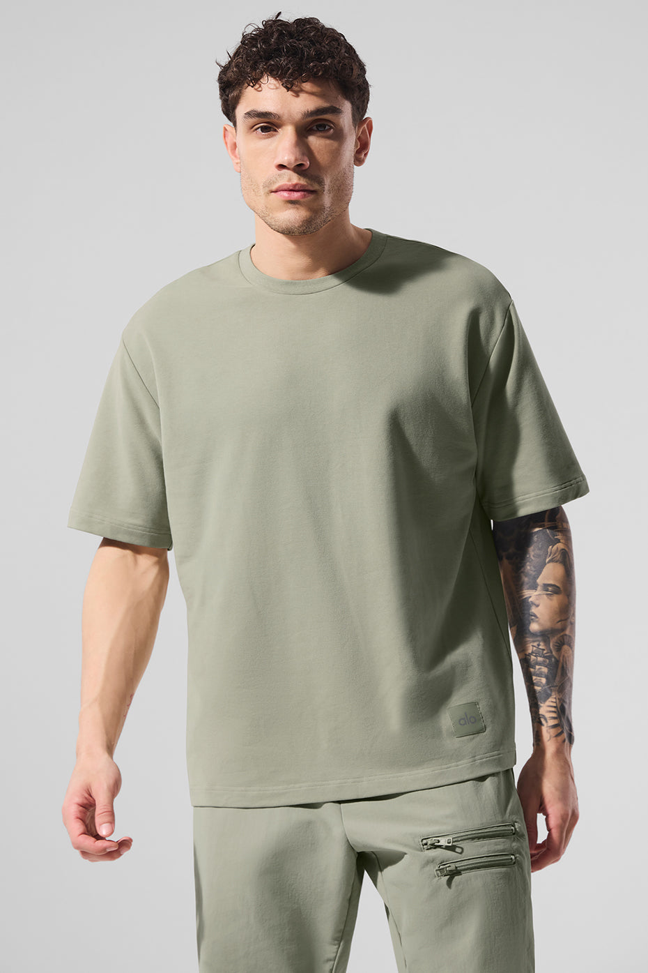 Front view of the oversized t-shirt in limestone showing extended sleeves