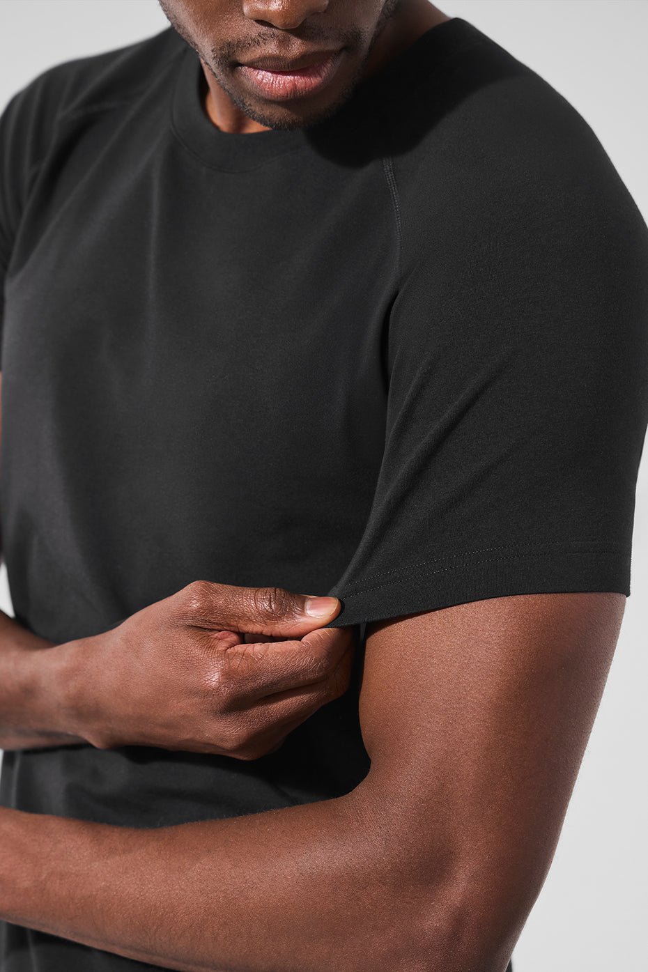 Front view of ALO Vapor Crewneck Tee in black, showcasing its sleek design.