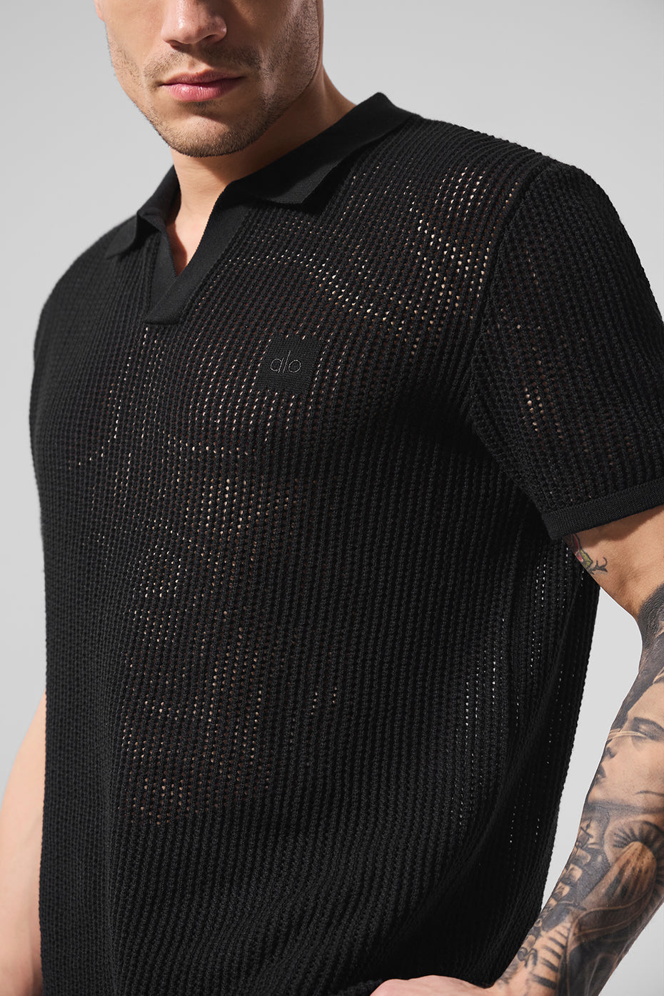 Close-up of open-knit texture on black polo shirt collar and neckline
