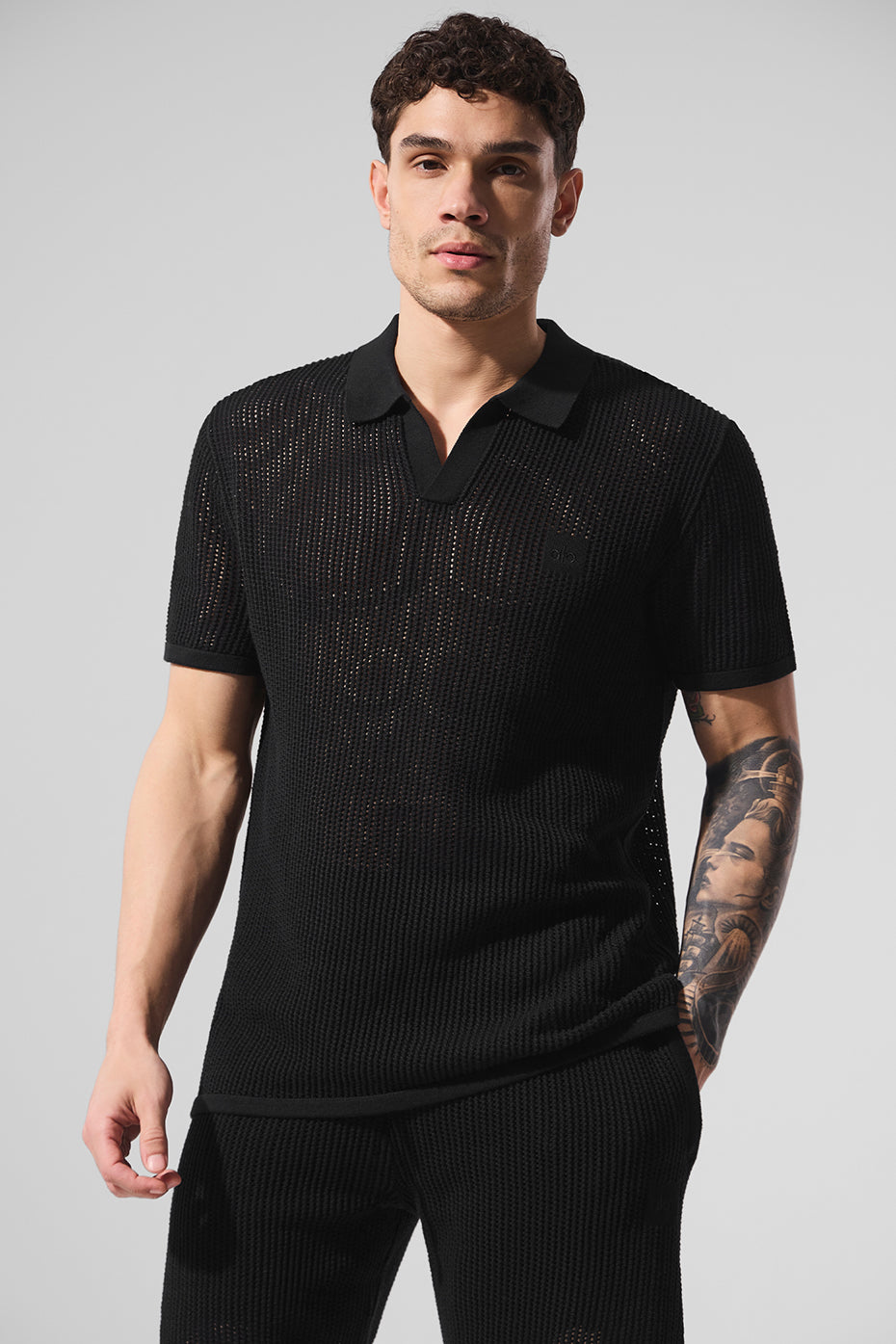 Side profile of polo and shirt ensemble worn casually in urban setting