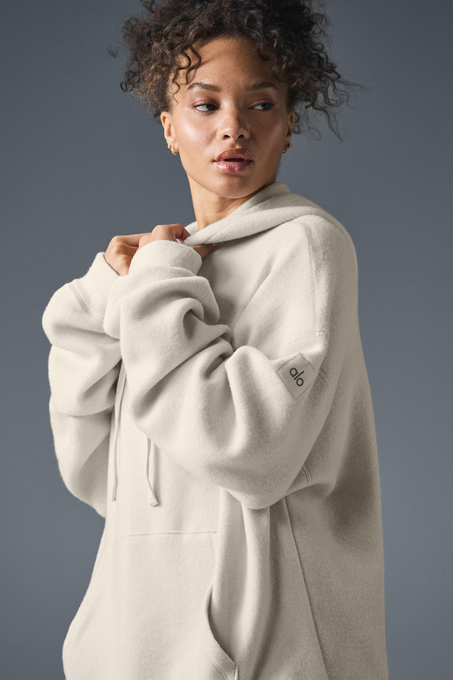 Woman lounging in a womens oversized hoodie, showcasing its relaxed fit.