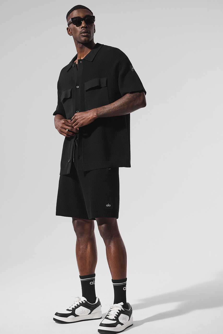 Front view of black knit short sleeve button-up sweater shirt worn casually