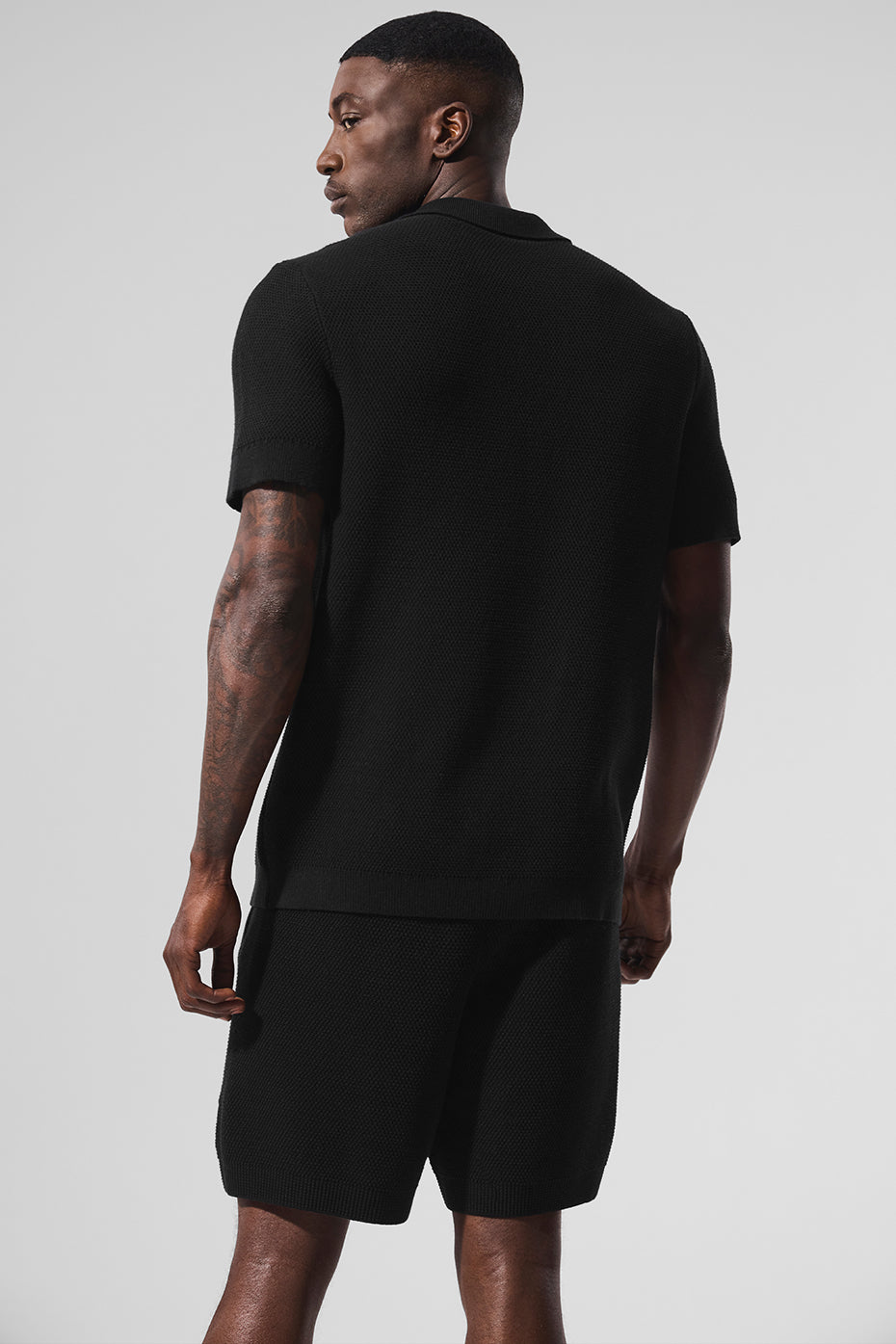 Close-up of the fabric texture of the black polo shirt.