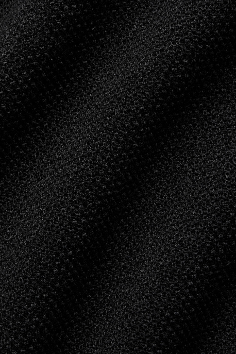 Close-up of the fabric texture of the black polo shirt.