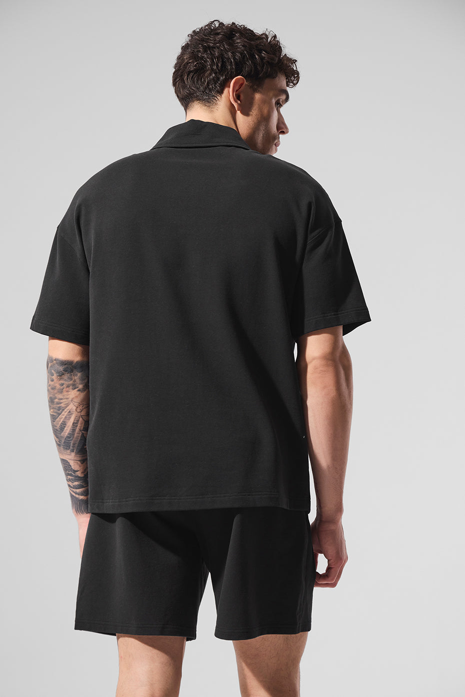 Casual look with black polo shirt paired with shorts.