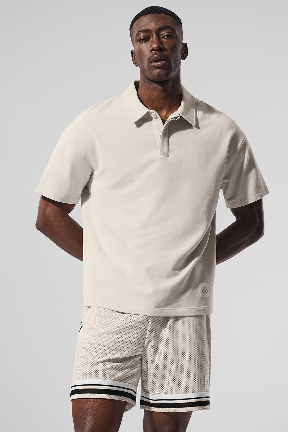 Front view of the black polo shirt on a model, highlighting its relaxed fit
