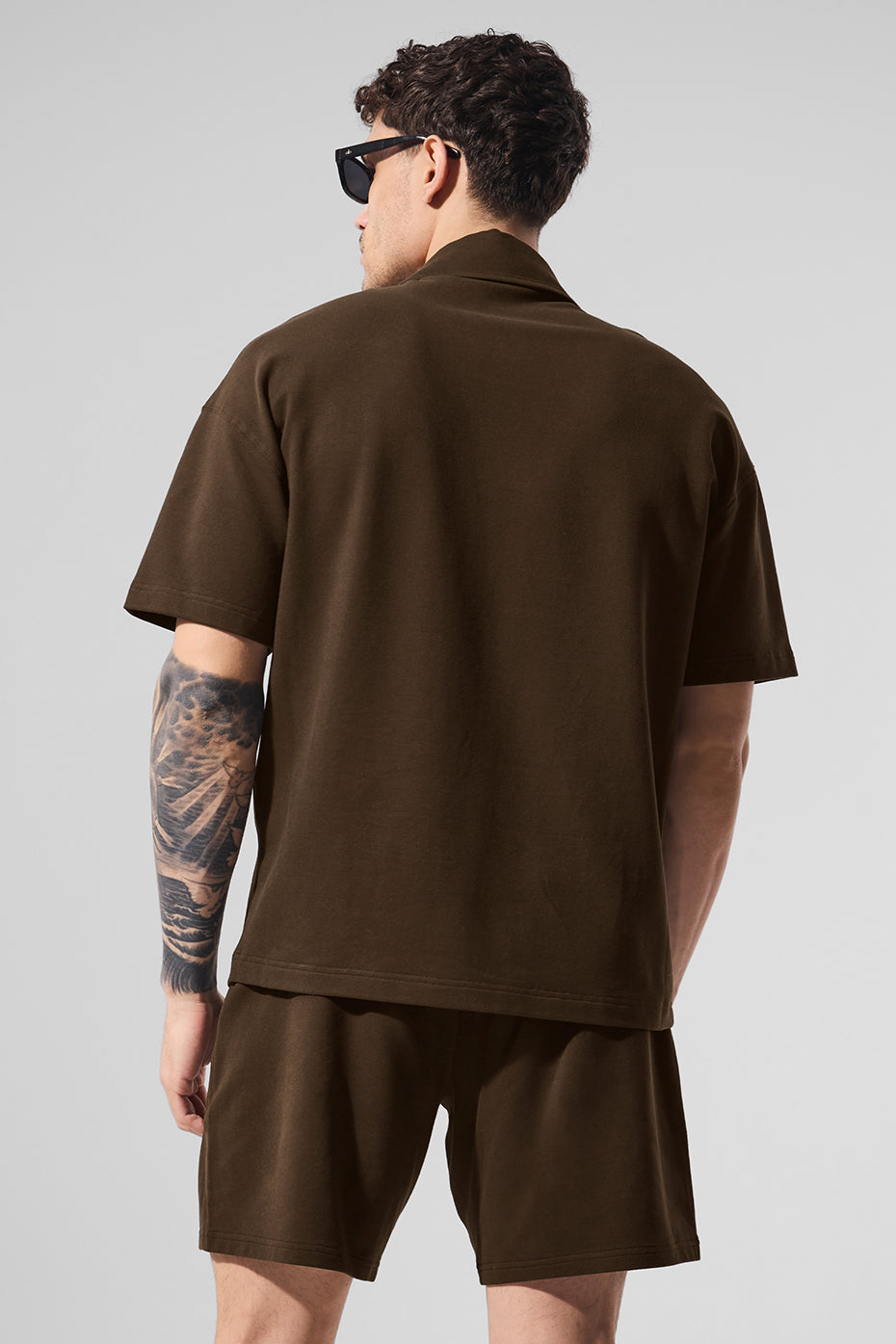Short sleeve shirt laid flat with espresso color tones and button details.