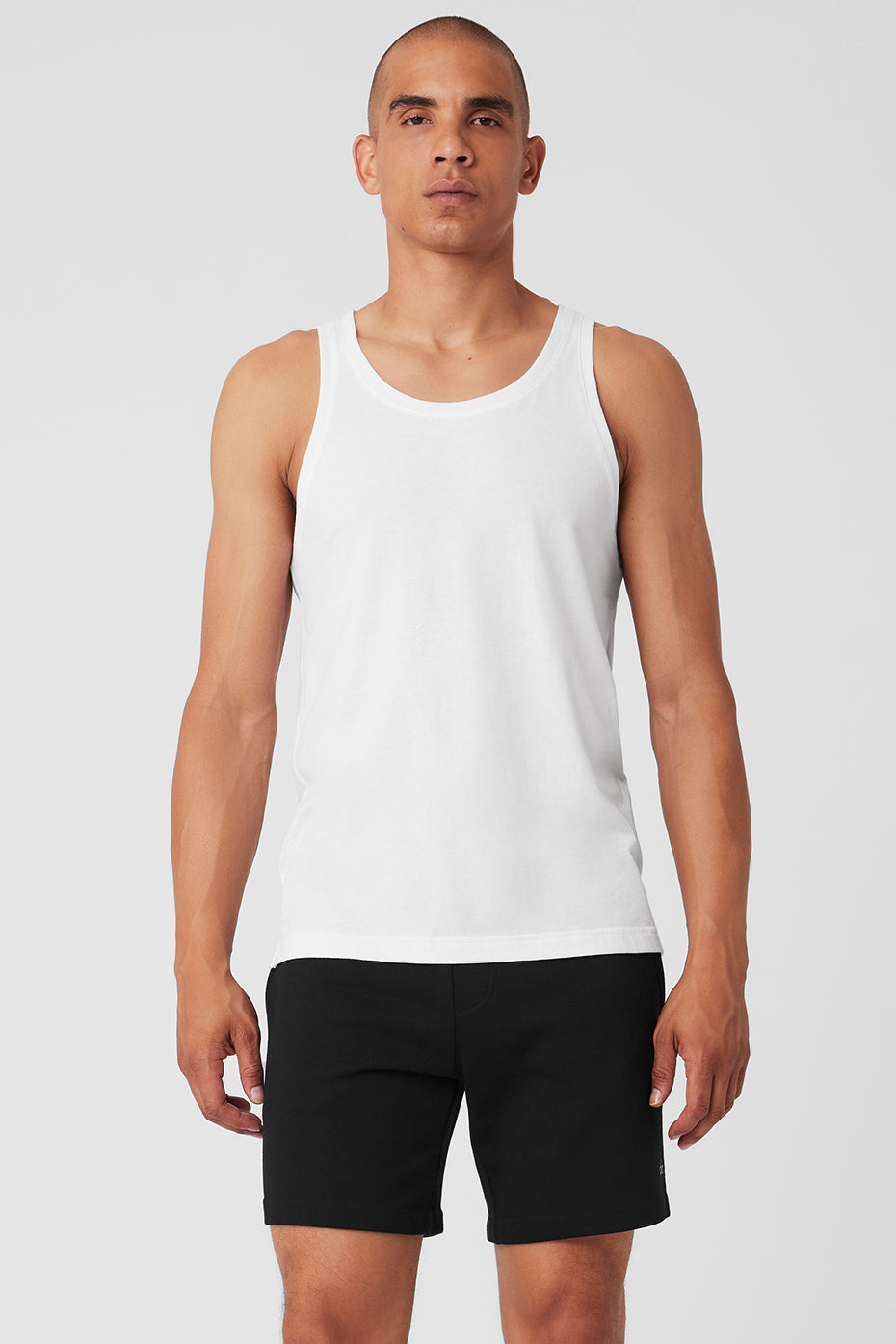Front view of white yoga tank top styled with leggings for studio wear