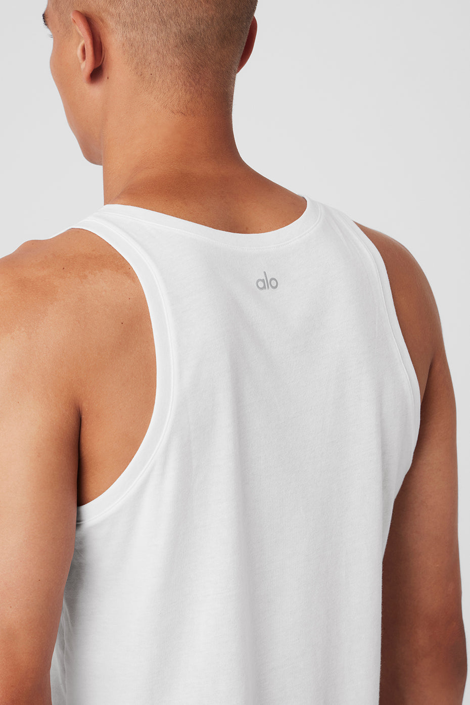 Front view of white yoga tank top styled with leggings for studio wear
