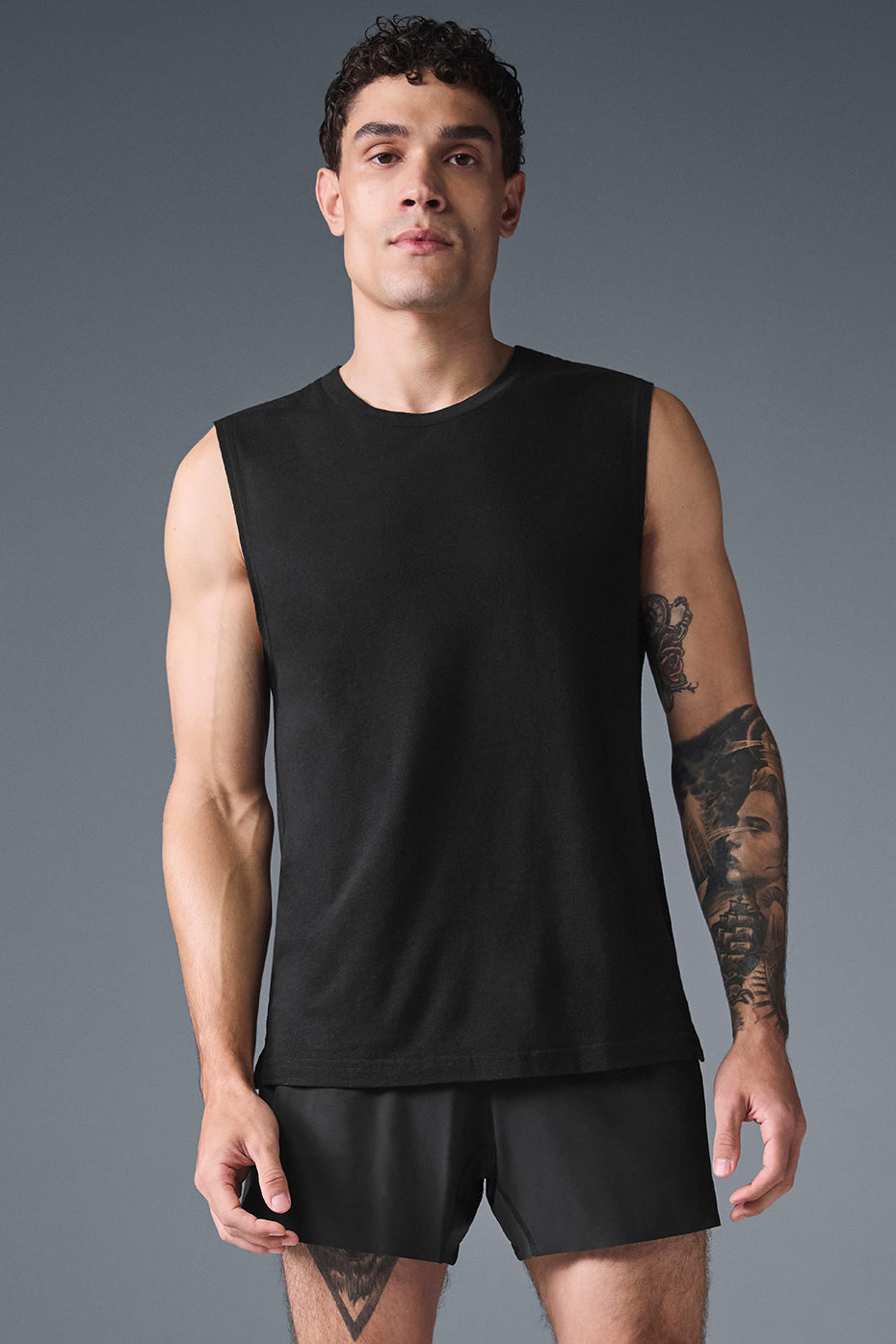 Black 437 Activewear muscle tank laid flat on a yoga mat