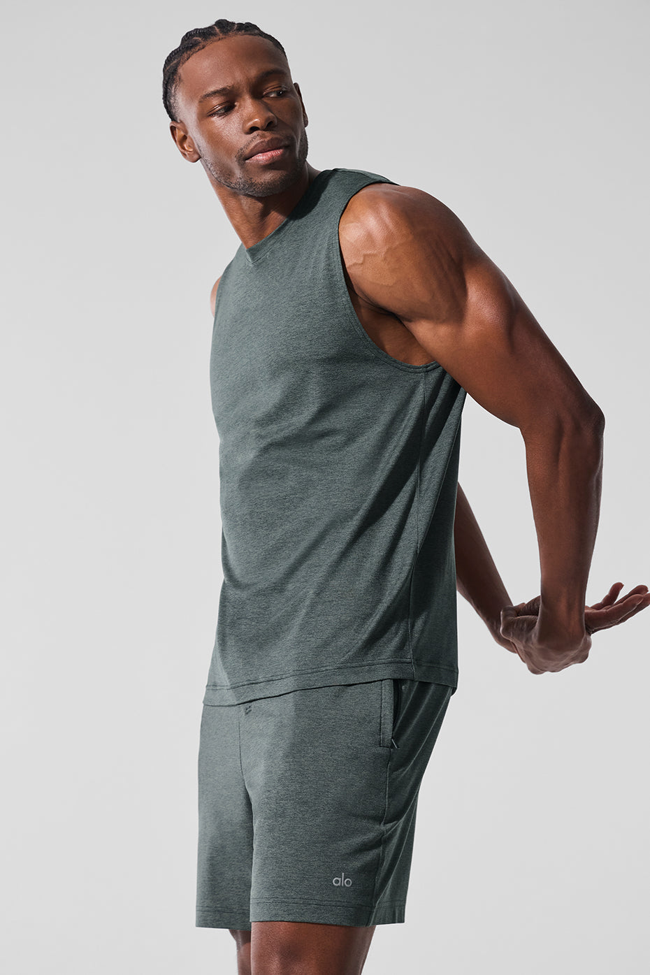 Model wearing the muscle tank paired with gym shorts and a hoodie.