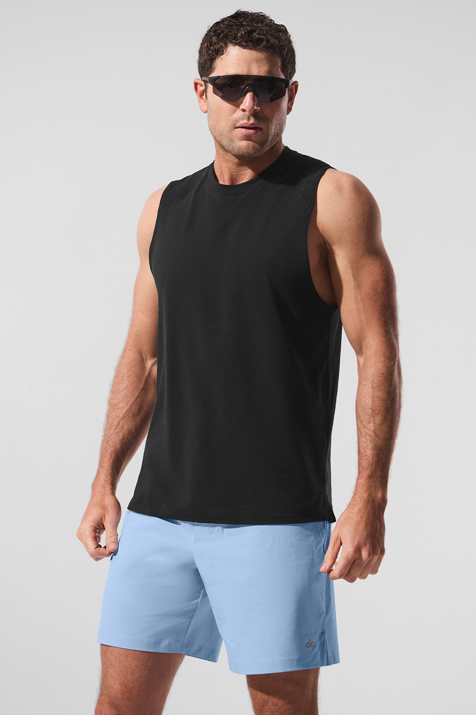 Front view of the black men's athletic tank top in gym setting