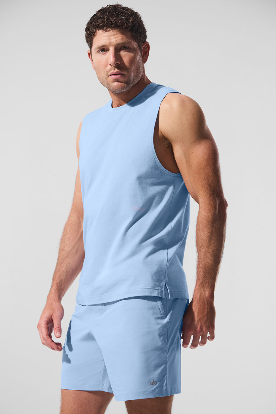 Front view of the Seashell Blue ALO Vapor Muscle Tank in a gym setting
