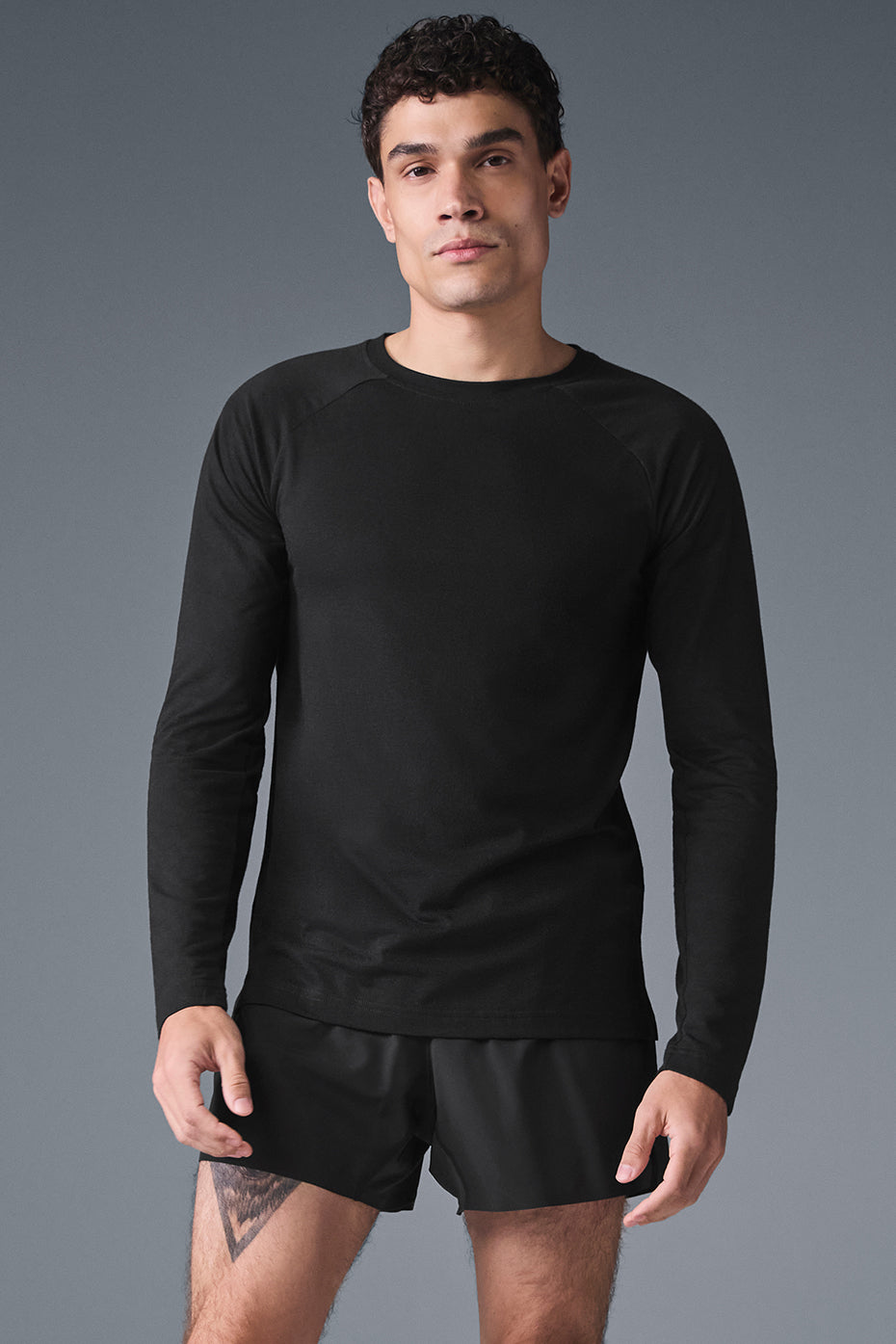Front view of the black long sleeve tee on a model, casual street style