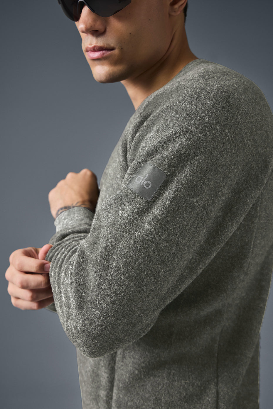 Model wearing the grey crew neck sweatshirt in an outdoor setting