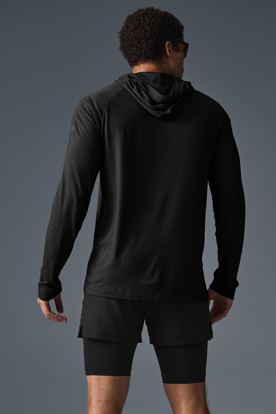 Model wearing the Core Hooded Runner during a workout session outdoors