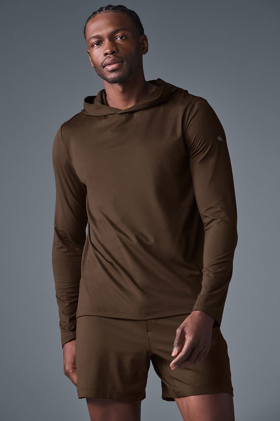 Model wearing the long sleeve hoodie during soccer training in a park setting