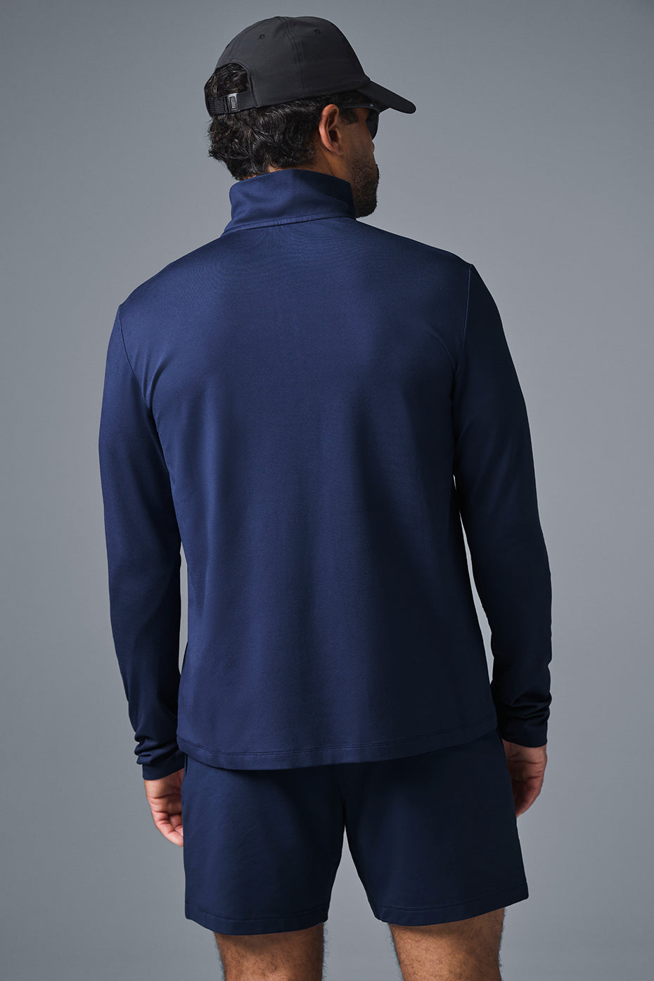 Model wearing moisture wicking t shirt layered beneath the quarter zip shirt outdoors.