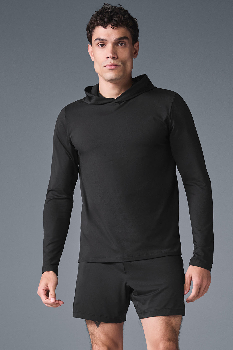 Front view of the black moisture-wicking long sleeve hoodie with hood, suitable for training or casual outfits