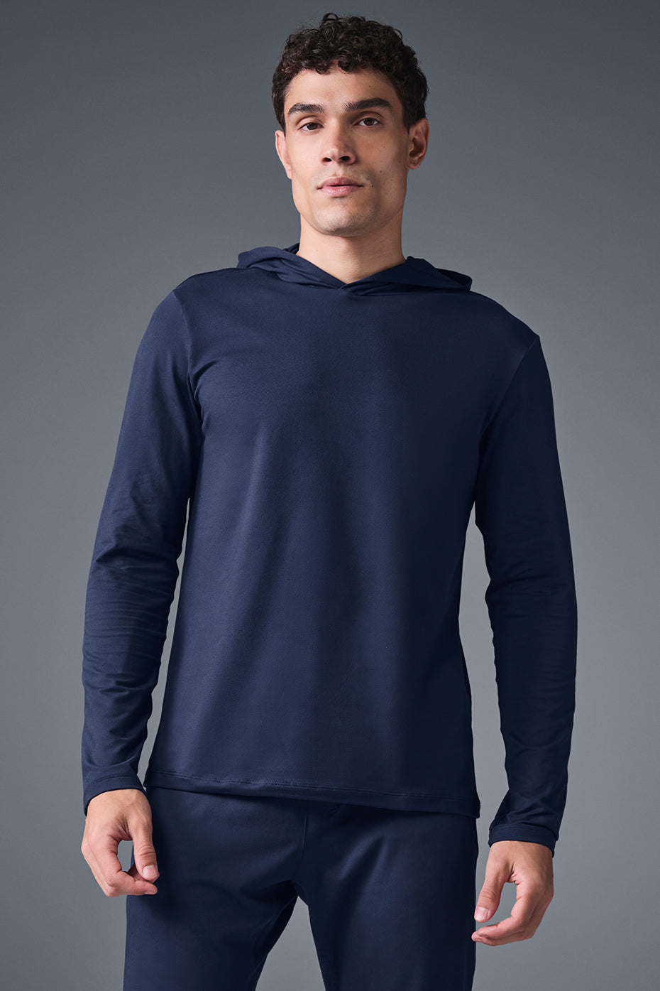 Front view of the Conquer Reform performance hoodie in navy during a workout.