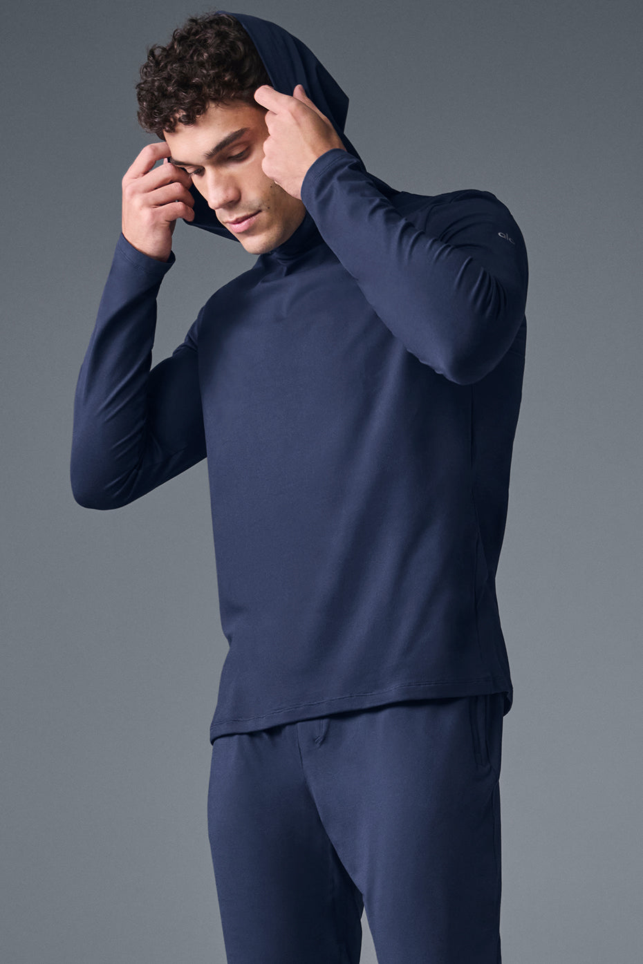 Front view of the Conquer Reform performance hoodie in navy during a workout.