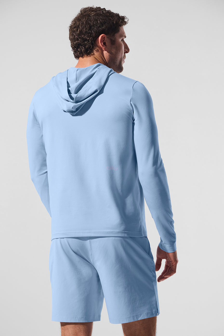 Lifestyle shot of man running in Seashell Blue moisture-wicking hoodie