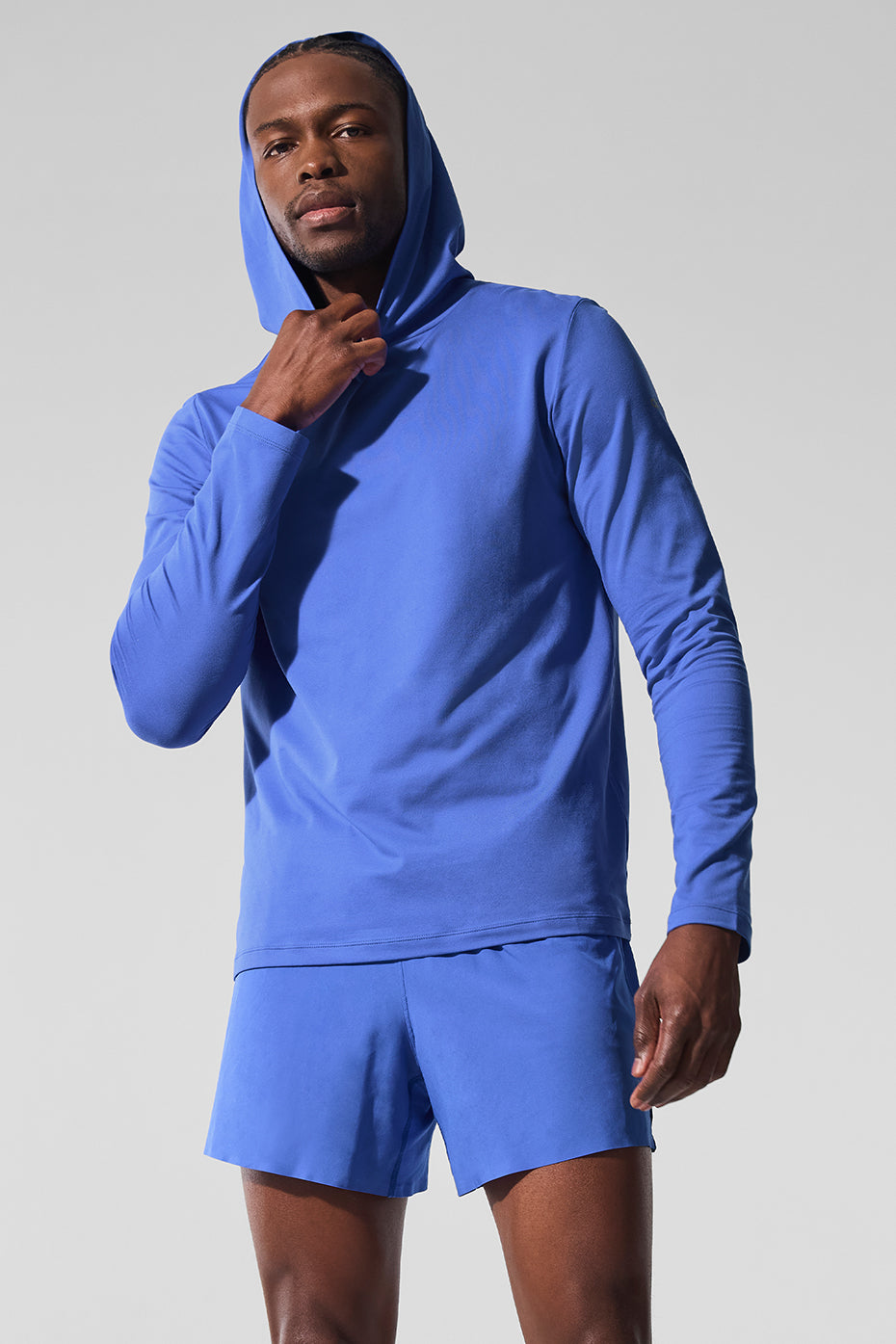 Athlete running in Conquer Reform training hoodie with hood up