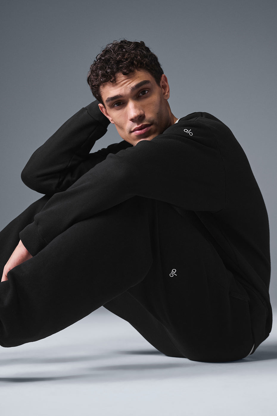 Close-up of the black crew neck pullovers cuffed hem and French terry fabric texture