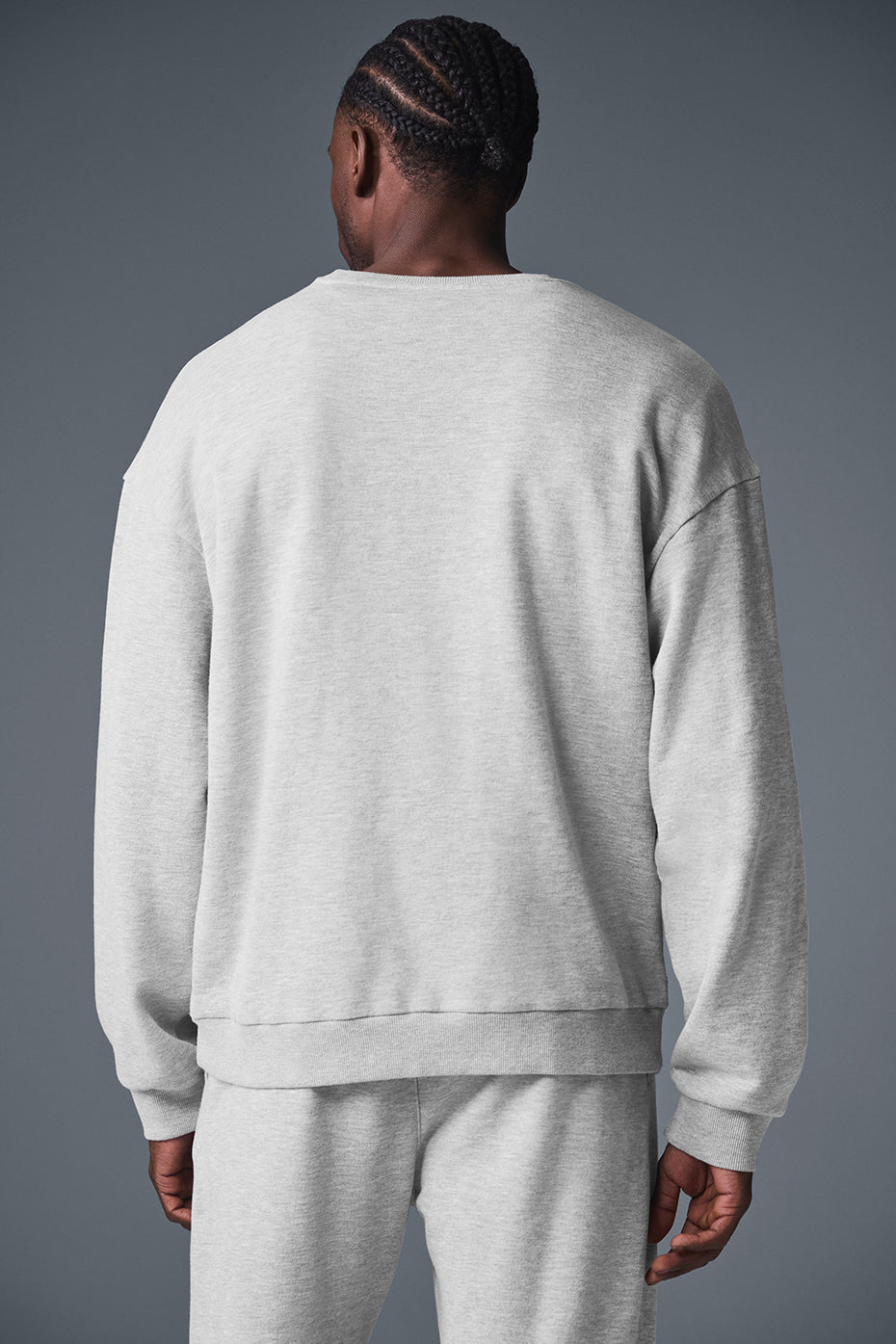 Model warming up in black crewneck sweatshirt, paired with track pants outdoors in Altoona