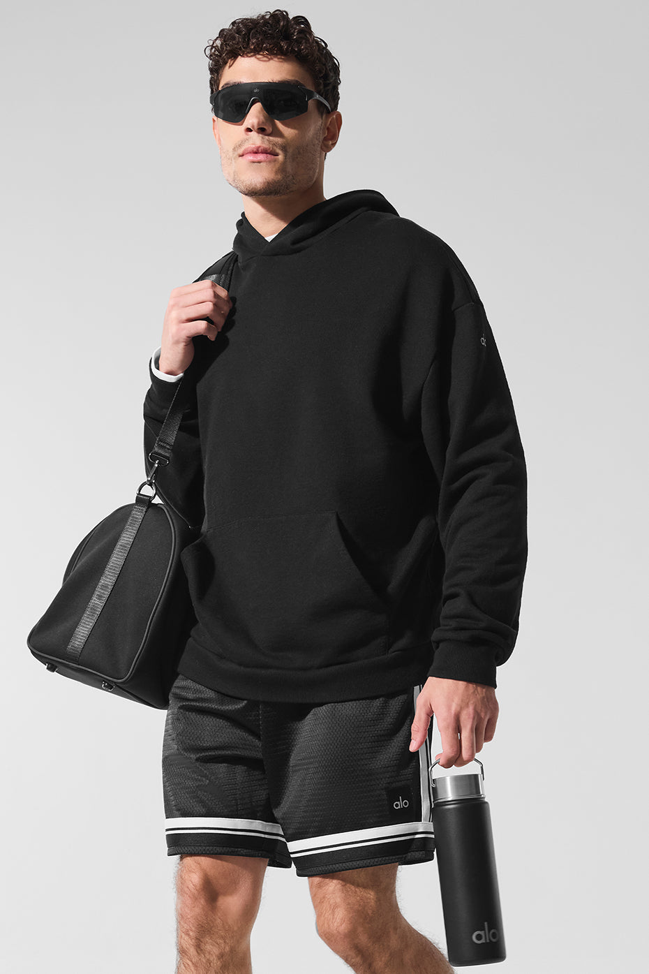 Model wearing the black essentials hoodie during a casual outing.