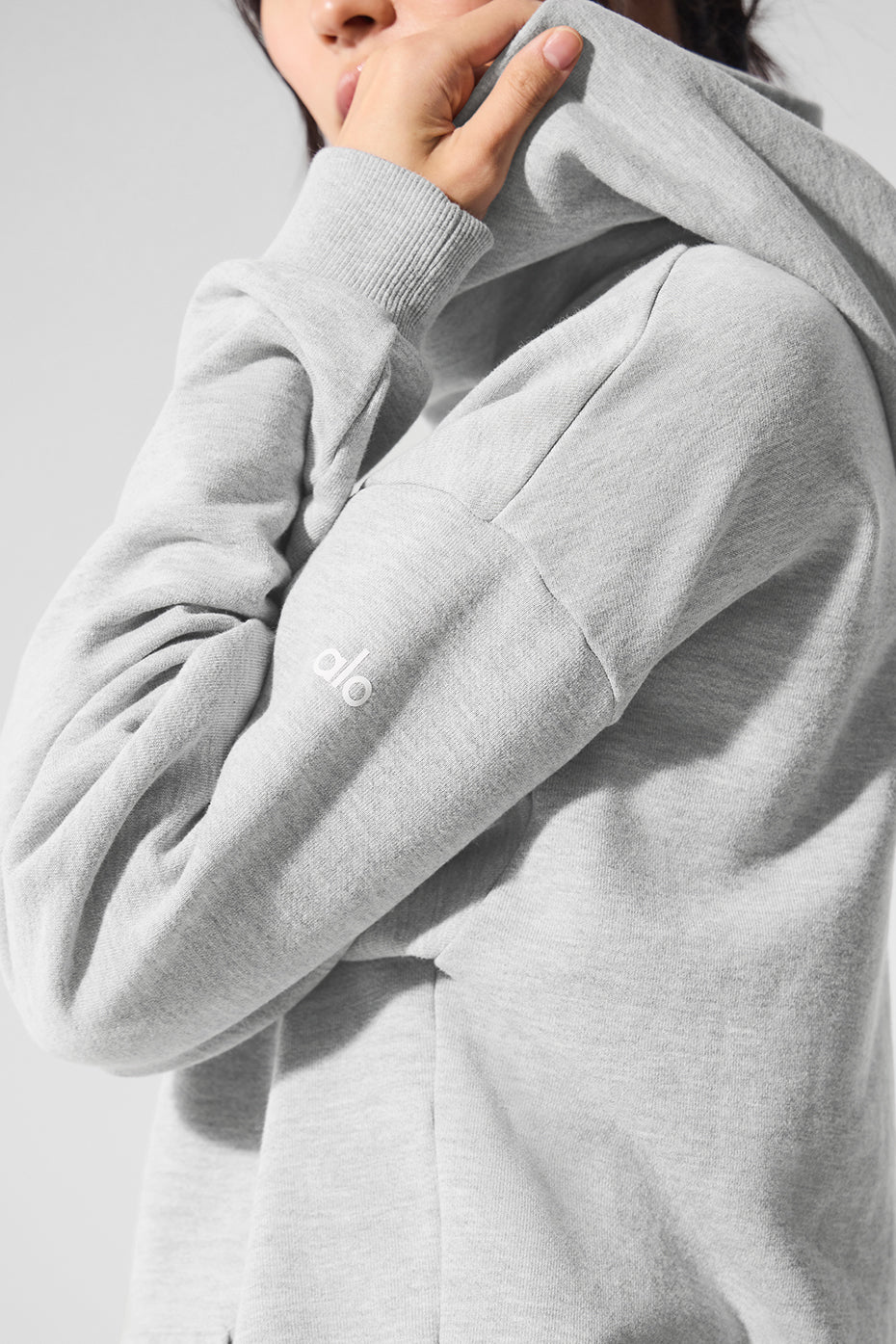 Front view of cozy comfort hoodie in athletic heather grey on a model during a workout