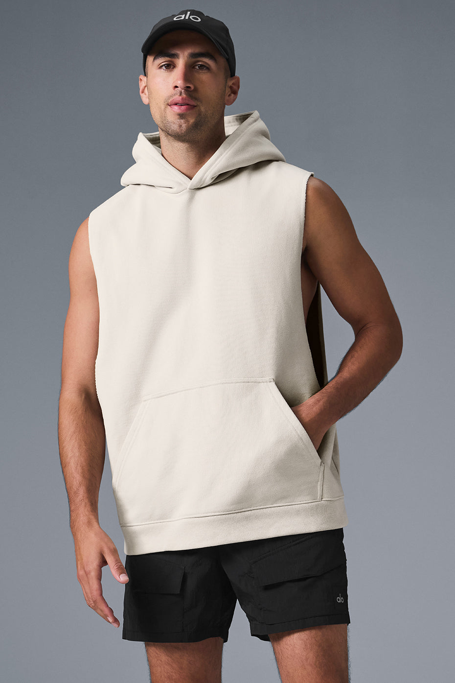 Front view of a sleeveless hoodie on a model in a gym setting