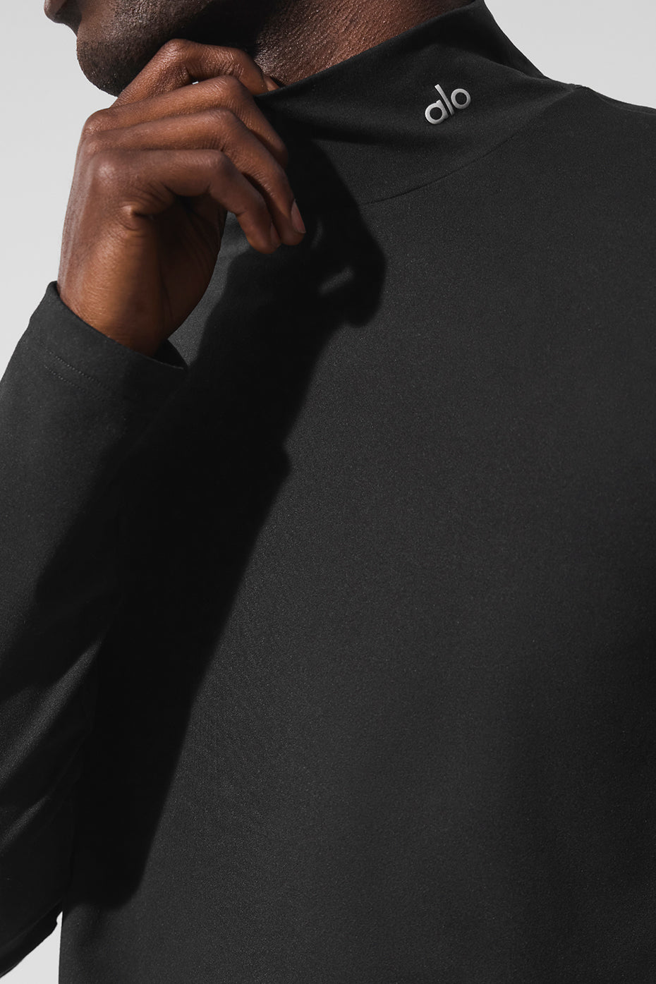Side view showcasing the reflective ALO logo on the shirt.