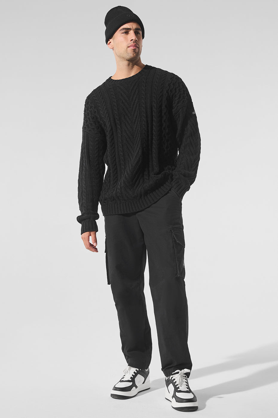 Front view of black cable knit sweater with crew neck for casual wear