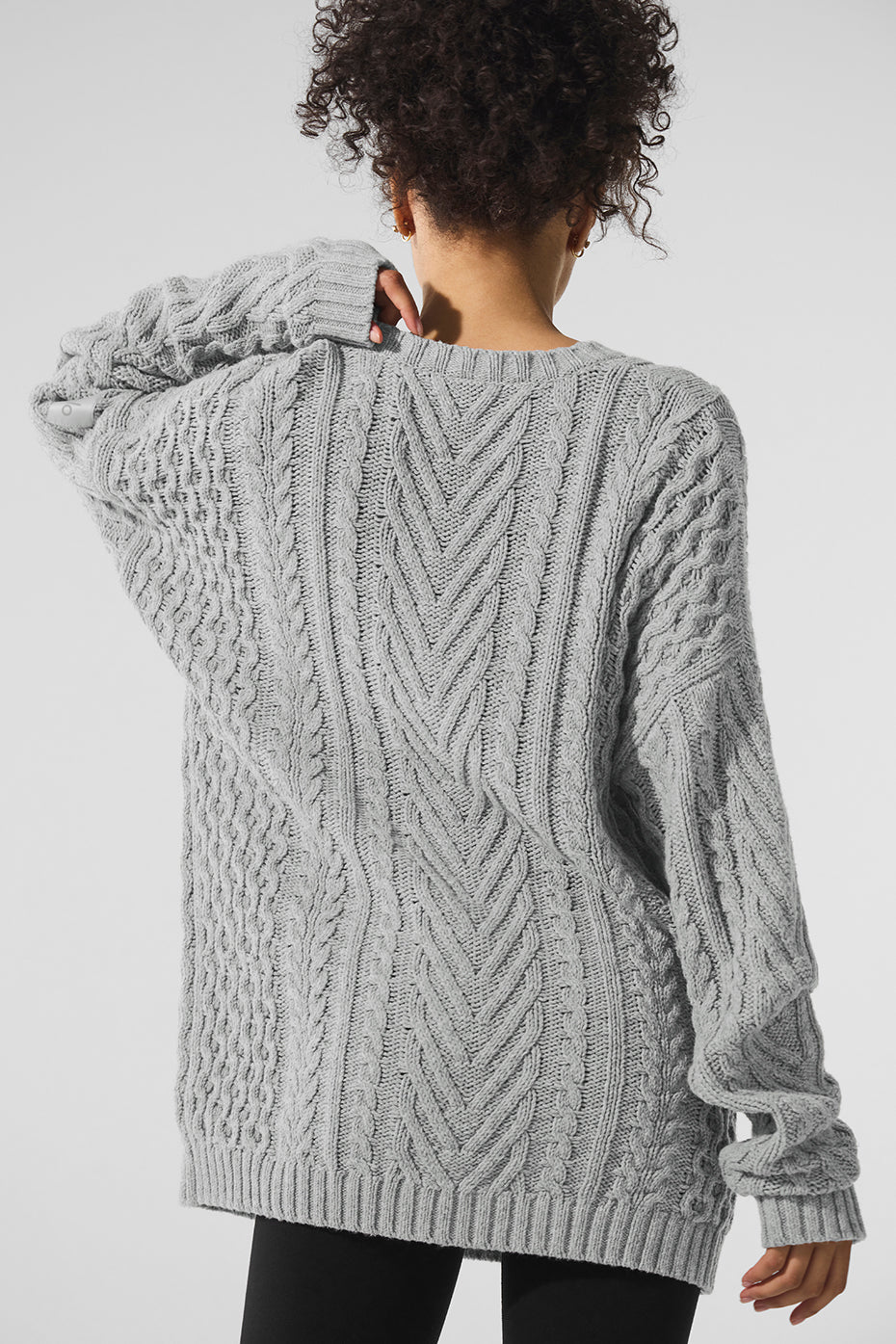 Close-up of the detailed cable knit pattern on the sweater