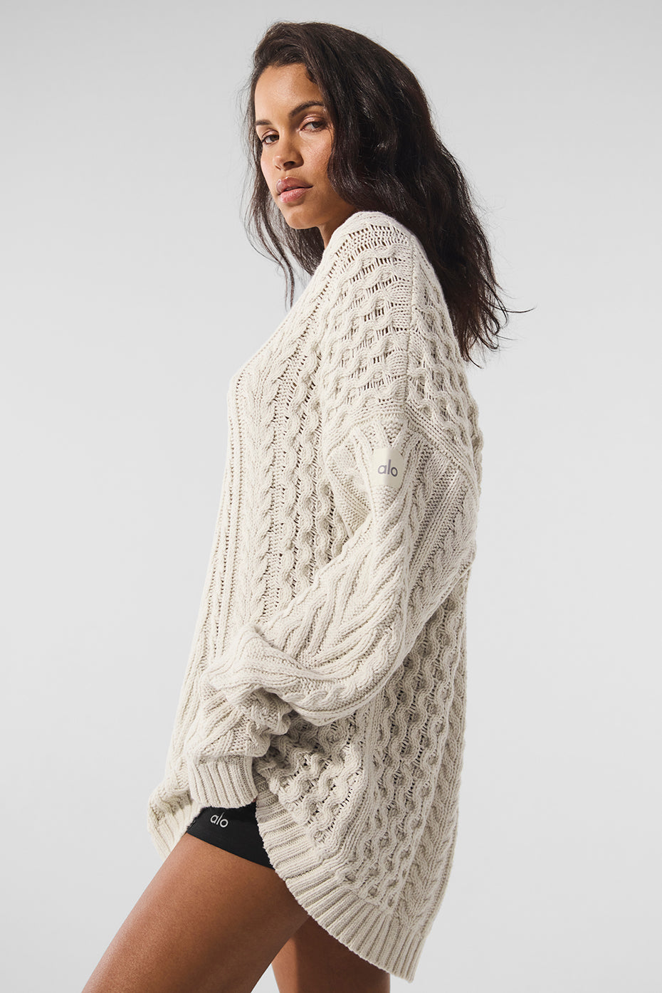 Model wearing a white cable knit sweater dress, ideal for evening outings.