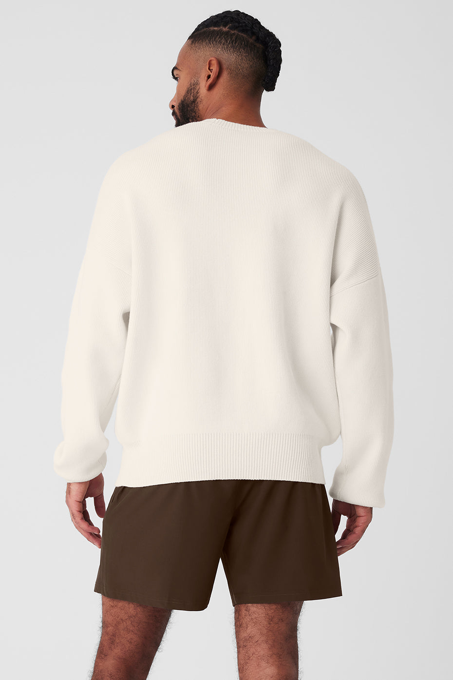 Model wearing oversized off the shoulder sweater in a casual setting.