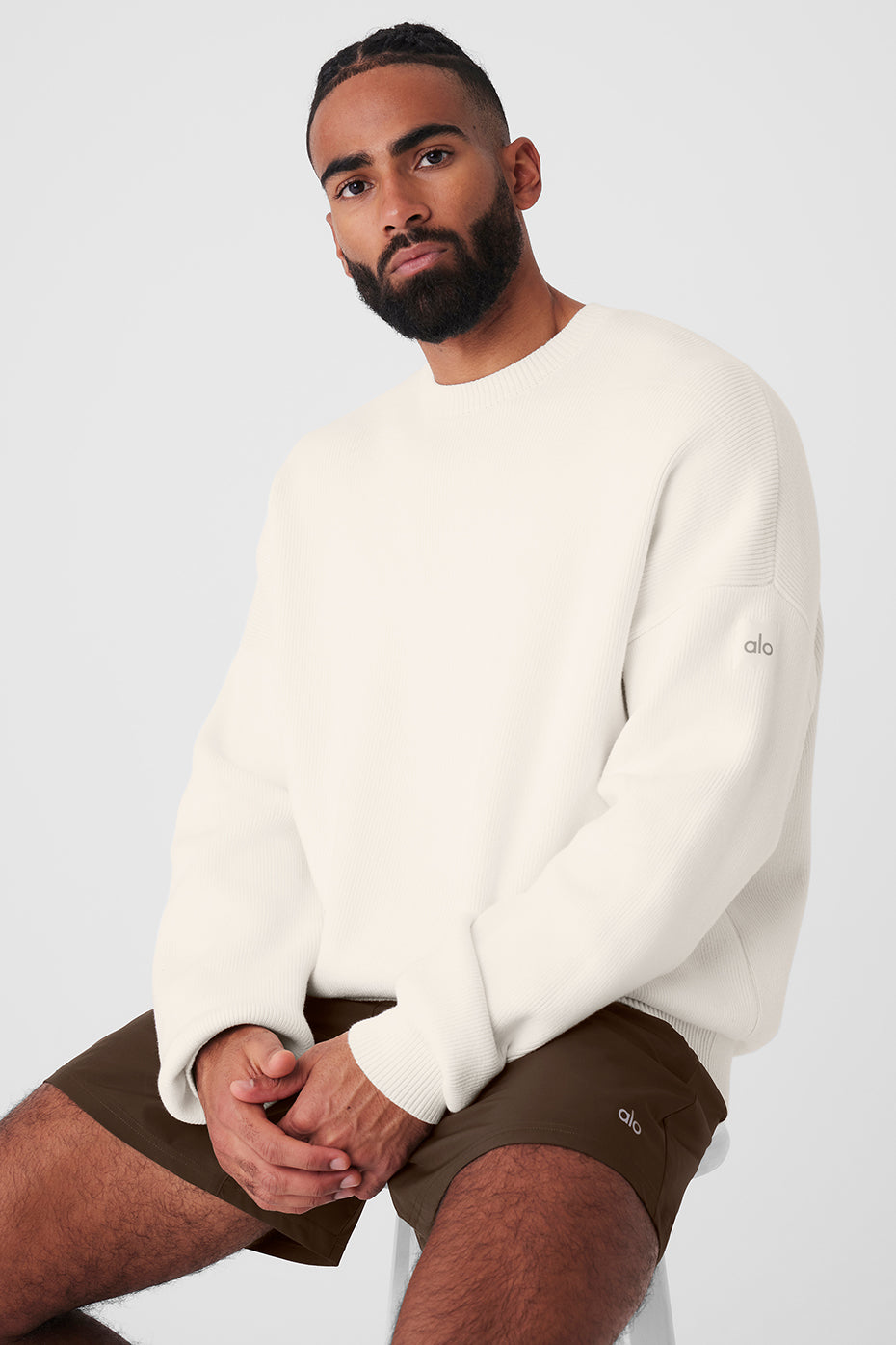 Model wearing oversized off the shoulder sweater in a casual setting.