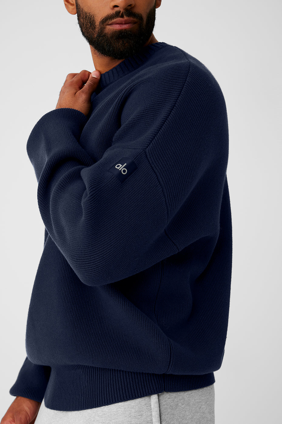 Close-up of the ribbed neckline on the navy blue chunky knit sweater.