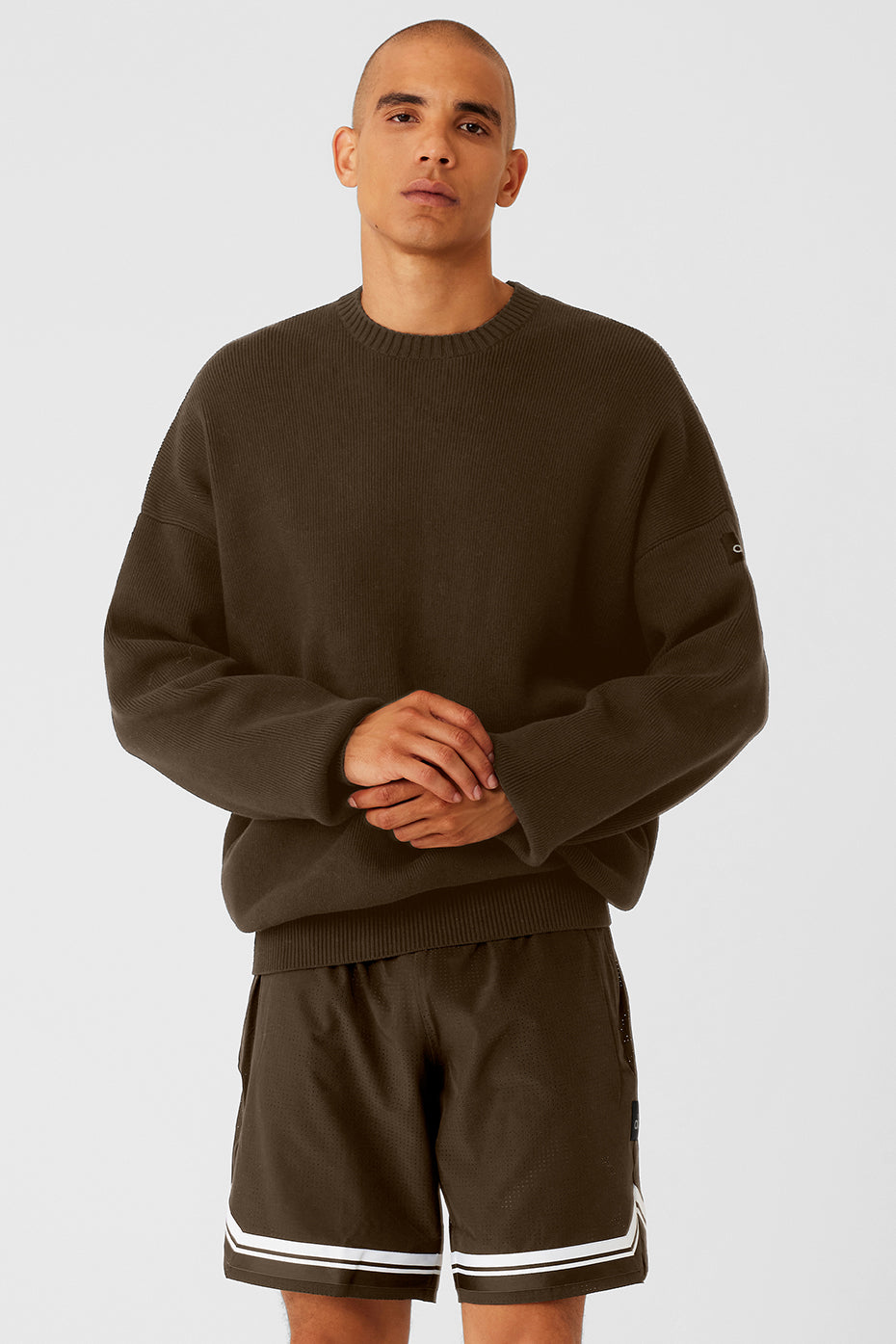 Front view of men's crew neck sweater in espresso color, styled with jeans
