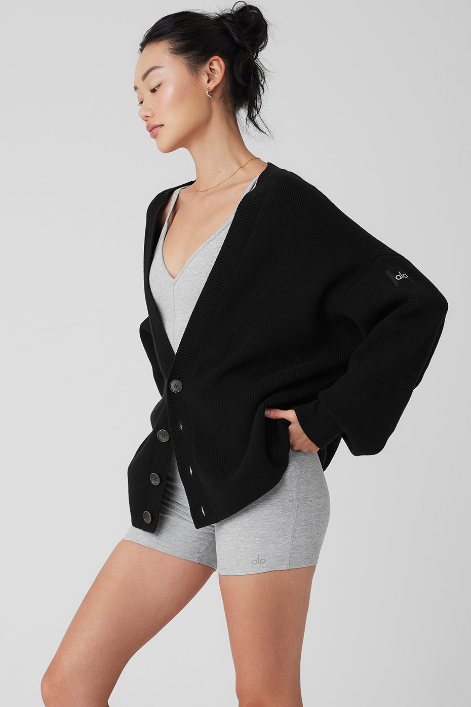 Styled black cardigan paired with trousers and boots for a chic dinner outfit.