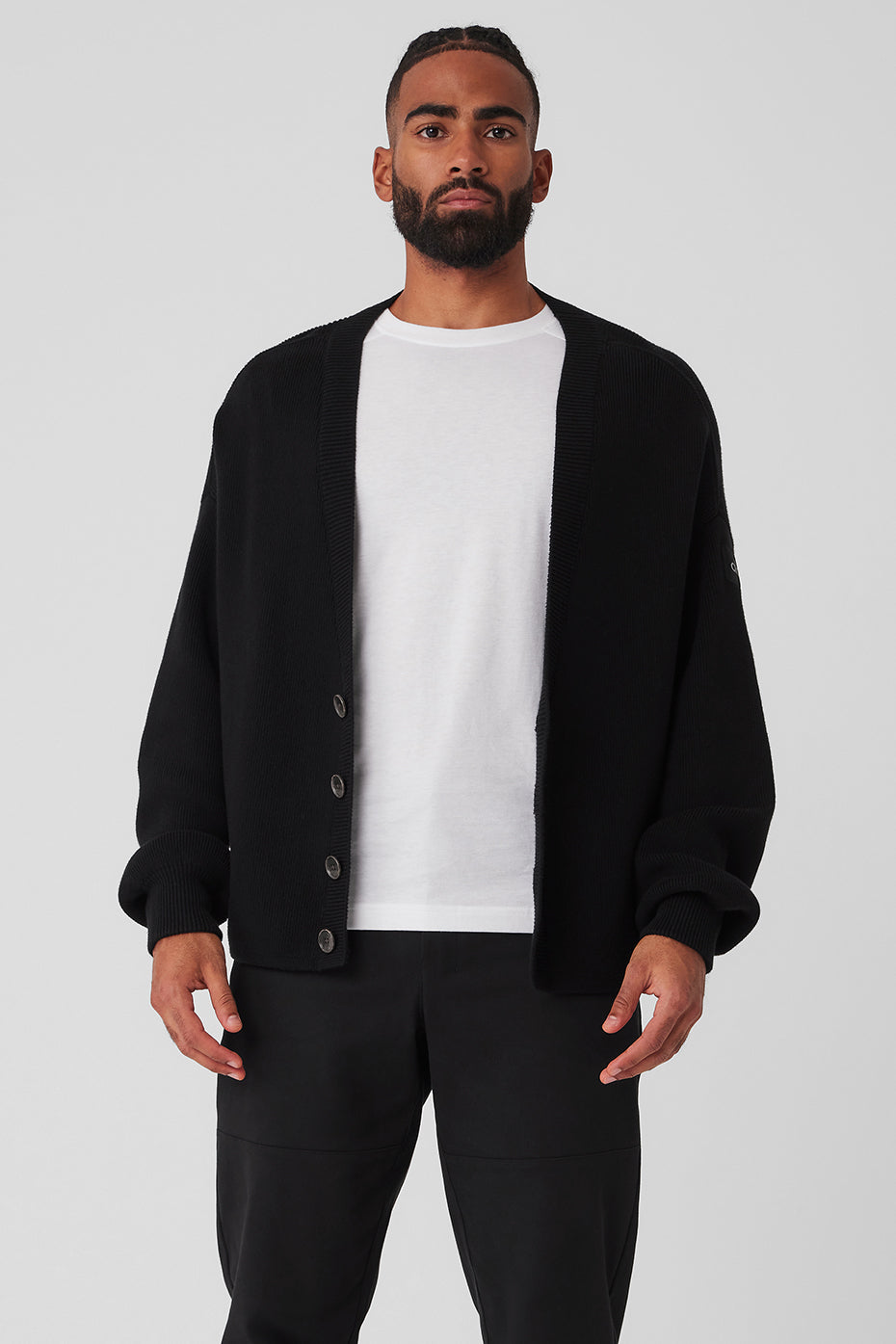 Front view of the black cardigan showing the four-button closure and ribbed cuffs