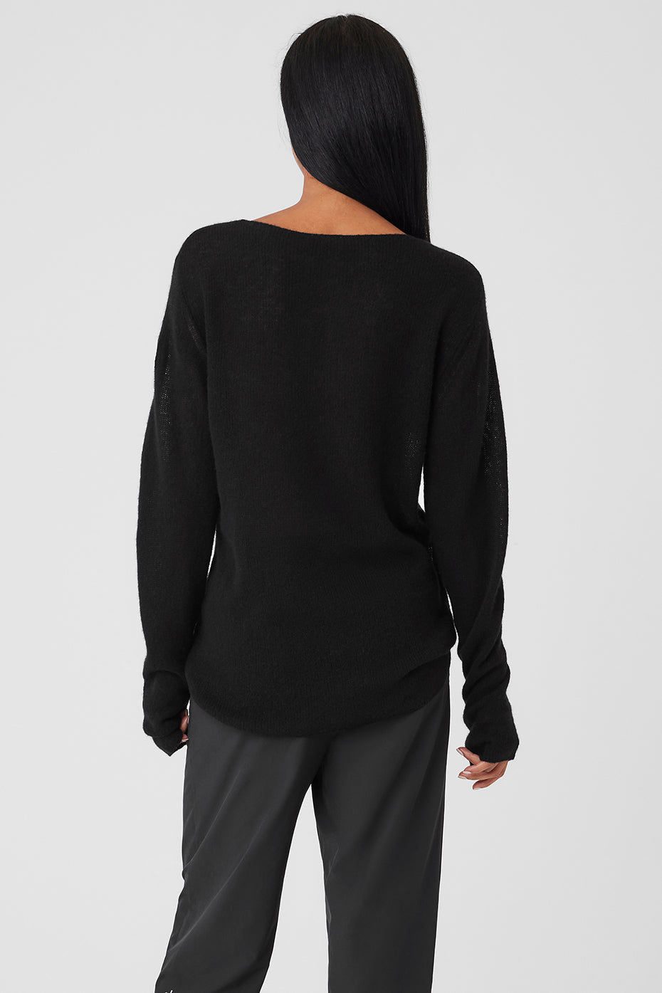 Model wearing the black cashmere long sleeve top layered under a stylish jacket.