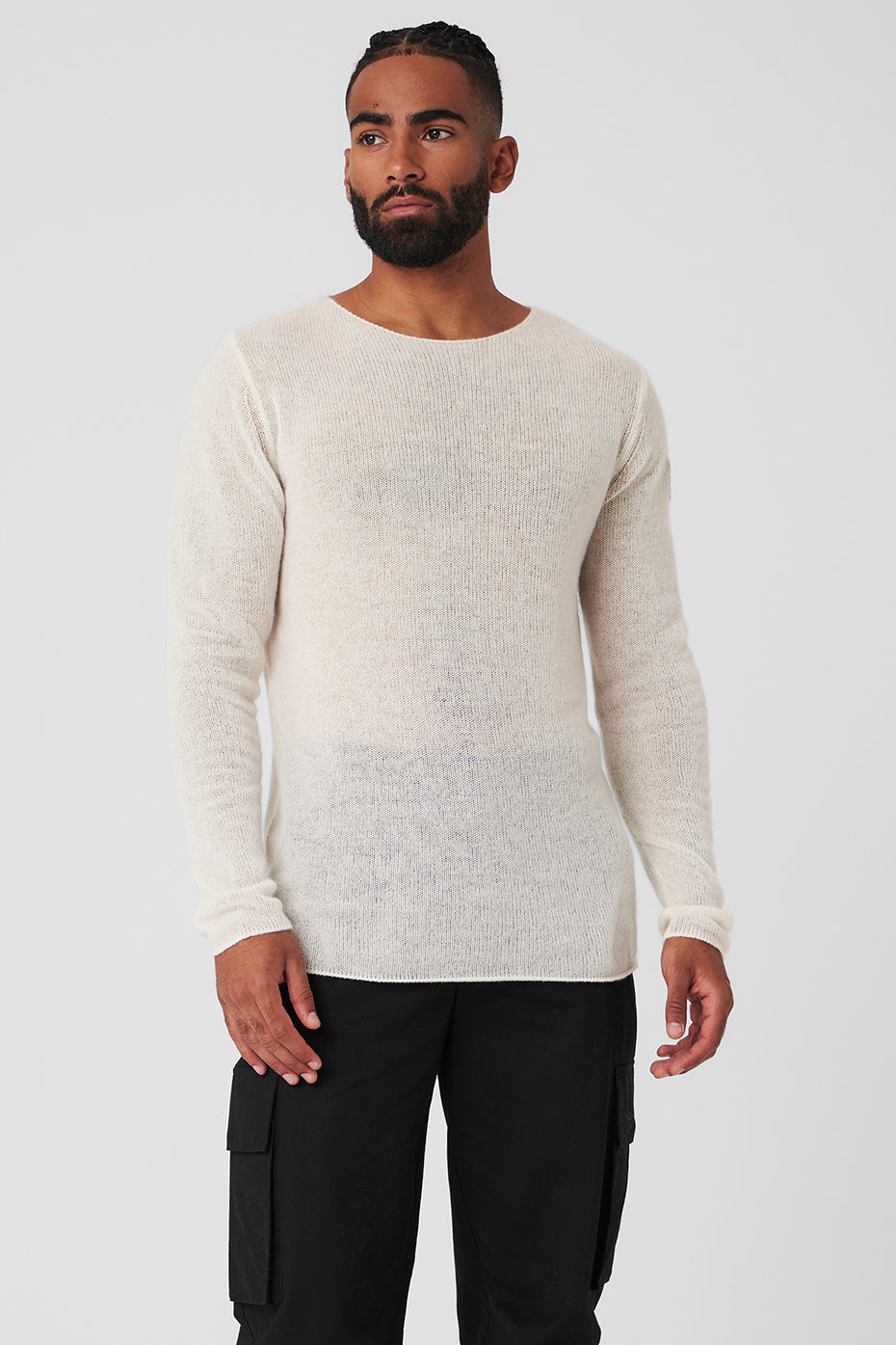 Front view of man wearing ivory cashmere sweater against winter backdrop.