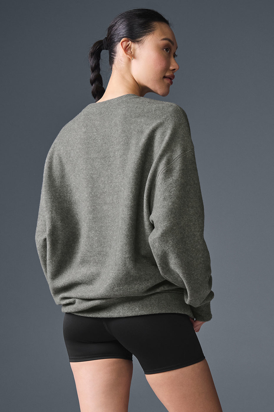 Model lounging in oversized crewneck sweatshirt with coffee cup